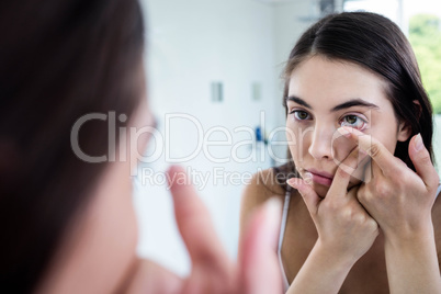 Brunette putting her contact lens
