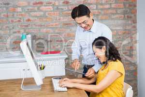 Happy man showing tablet to his pregnant wife