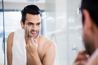 Shirtless man looking in the mirror