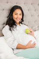 Pregnant brunette holding apple