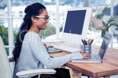 Smiling Asian woman using laptop and digital board