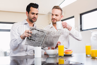 Smiling gay couple reading newspaper