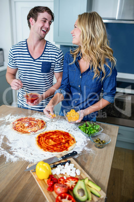 Smiling couple preparing pizza