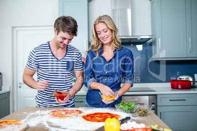 Smiling couple preparing pizza