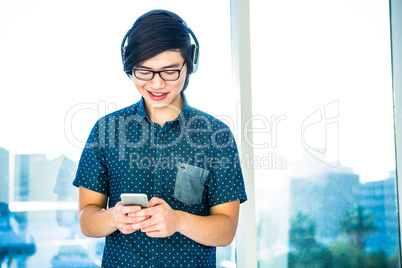 Smiling hipster businessman listening music