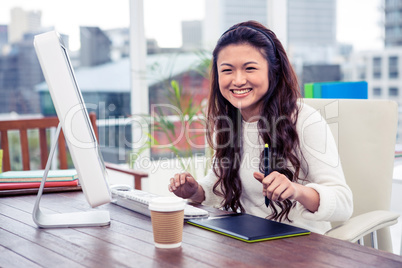 Smiling Asian woman using digital board and computer