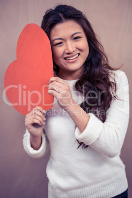 Smiling woman holding a paper heart