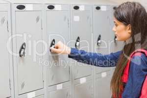 Unsmiling student opening her locker