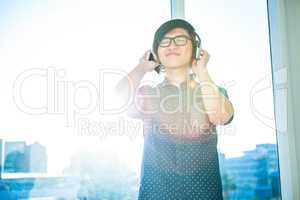 Smiling asian businessman listening to music