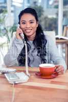 Smiling Asian woman on phone call holding mug