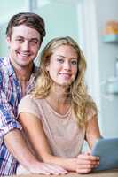 Cute couple using tablet computer in the kitchen