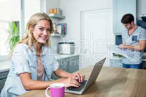 Happy couple using laptop and reading