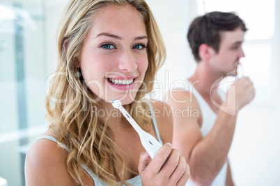 Young couple brushing their teeth at home