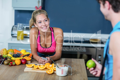 Healthy couple talking and holding fruit