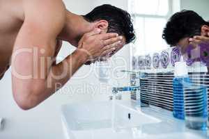 Handsome man washing his face