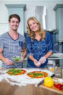 Smiling couple preparing pizza