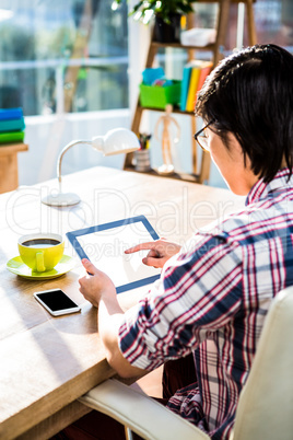 Above shoulder view of hipster using tablet