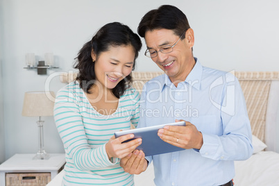 Happy couple using tablet