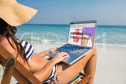 Composite image of pretty brunette using laptop on deck chair Composite image of pretty brunette using laptop on deck chair