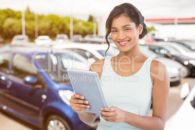 Composite image of portrait of smiling businesswoman using table