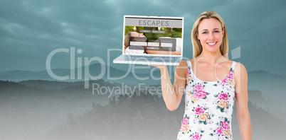Composite image of smiling blonde holding laptop and posing