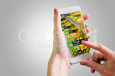 Composite image of hand holding smartphone