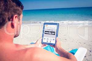 Composite image of man using digital tablet on deck chair at the