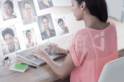 Composite image of businesswoman using laptop at desk in creativ