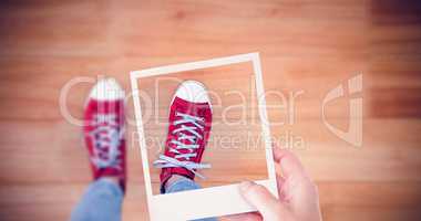 Composite image of hand holding polaroid picture