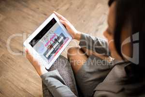 Composite image of businesswoman using tablet