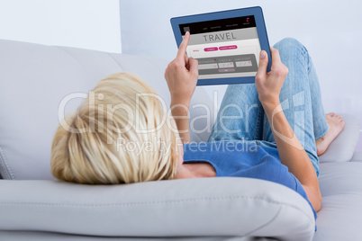 Composite image of blonde woman using her tablet on the couch