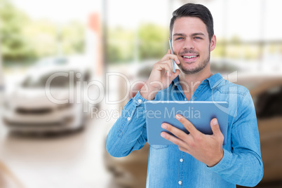 Composite image of handsome man holding digital tablet while tal