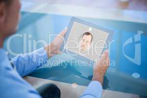 Composite image of businessman using his tablet