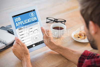 Composite image of rear view of man using tablet on wooden table