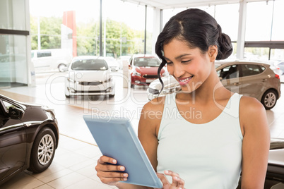 Composite image of smiling businesswoman using digital tablet