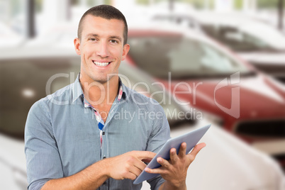 Composite image of smiling businessman using tablet computer ove