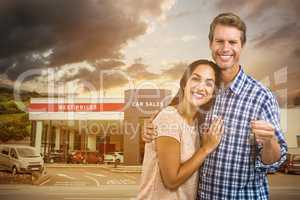 Composite image of portrait of happy couple with keys