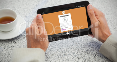 Composite image of businessman holding small tablet at table
