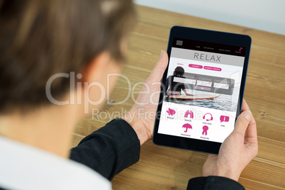 Composite image of businesswoman using tablet at desk