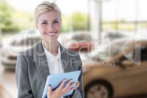 Composite image of smiling buisnesswoman using digital tablet