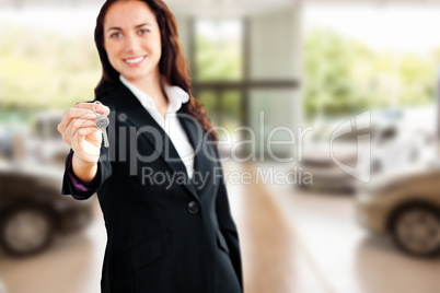 Composite image of smiling businesswoman holding a key