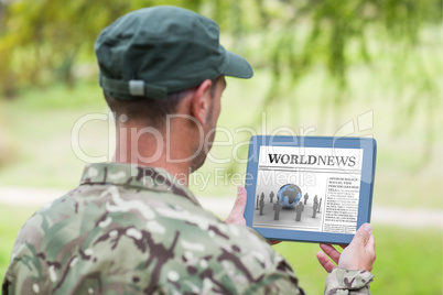 Composite image of army man using tablet