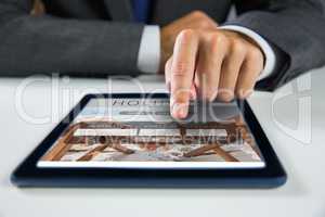 Composite image of businessman using digital tablet