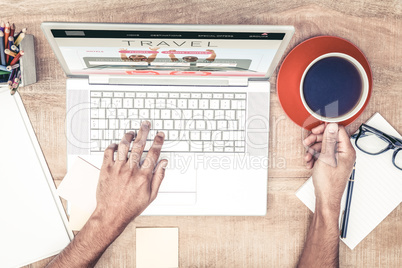 Composite image of businessman having coffee while typing on lap