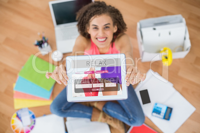 Composite image of smiling businesswoman showing digital tablet