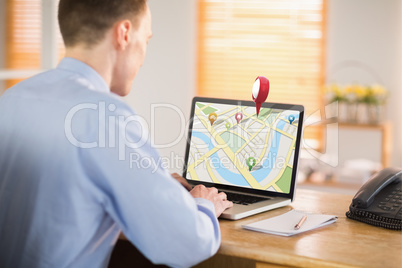 Composite image of businessman working on his laptop