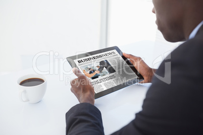 Composite image of businessman using digital tablet