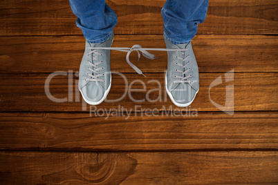 Composite image of low section of man with shoelaces tied togeth