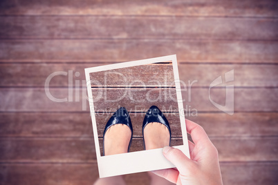 Composite image of hand holding polaroid picture