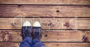 Composite image of low section of man standing on hardwood floor